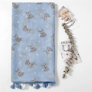 Light blue scarf with cute fox print and tassel fringe displayed with elegant lifestyle props