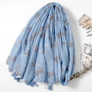 Close-up of light blue scarf with fox patterns and white tassels on white background