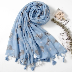 Detail of light blue scarf with fox and heart prints featuring decorative blue tassels