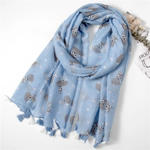 Detail of light blue scarf with cartoon fox prints, heart patterns and fringe edges