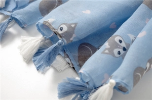 Detail of light blue scarf with fox patterns and blue-white decorative fringe
