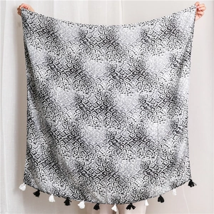 Détail d'un châle à imprimé léopard avec franges montrant la texture du tissu