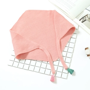 Détail d'une écharpe en tricot rose pour enfant avec glands colorés et maille douce