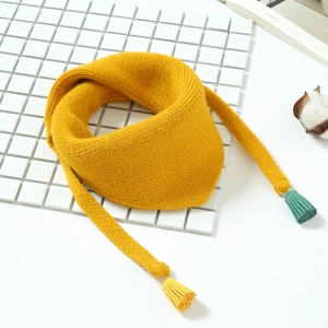 Détail de l'écharpe en maille côtelée jaune avec des glands colorés et des attaches