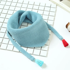 Détail de l'écharpe en maille bleu clair pour bébé avec pompons colorés et fils doux