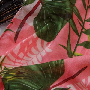 Detailed close-up of tropical leaf print on pink cotton linen scarf showing fabric texture