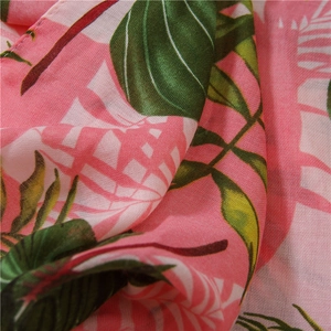 Detail of tropical leaf print on lightweight pink cotton linen scarf with soft texture