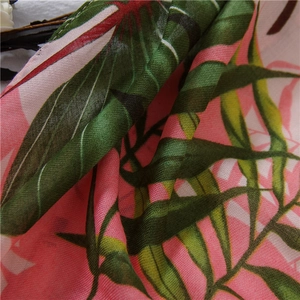 Macro shot of tropical palm leaf print on lightweight pink semi-transparent fabric