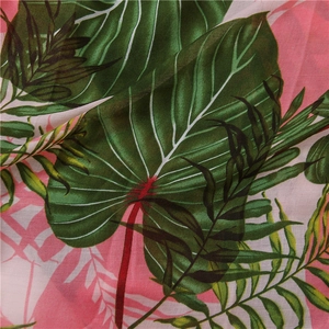 Detail shot of tropical leaf print on lightweight cotton linen fabric with soft draping