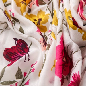 Close-up of floral and butterfly print on soft white cotton linen fabric detail