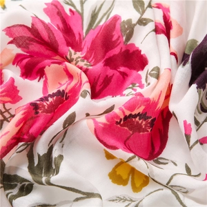 Detail of floral printed fabric showing soft cotton-linen texture and vibrant rose patterns