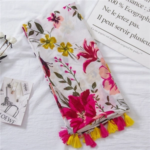 Detailed view of floral scarf with vibrant flower prints and colorful fringe tassels