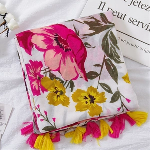 Close-up of floral cotton linen scarf with pink fringe and colorful flower prints