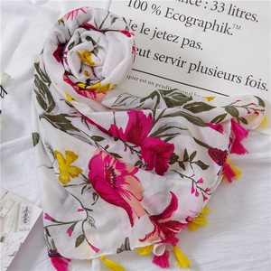Detail view of floral print scarf with vibrant flower patterns and colorful tassels