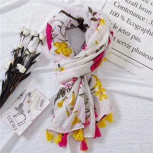 Detailed close-up of floral print cotton scarf with dual-color tassel fringes and soft texture