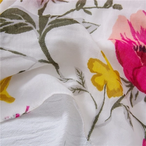 Macro shot of colorful floral print on soft breathable cotton-linen fabric texture