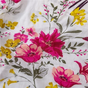 Close-up of lightweight floral cotton linen fabric with pink and yellow flower patterns