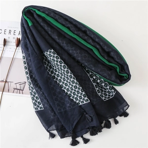 Elegant navy blue scarf with white geometric rings, green borders and fringe details