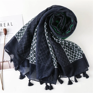 Elegant navy blue floral scarf with tassels shown in a stylish flat lay spiral display