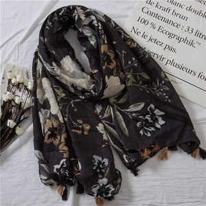 Close-up of floral print cotton linen shawl with retro pattern and black fringe tassels