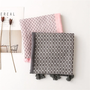 Close-up of elegant polka dot scarves with matching tassels in pink and grey tones