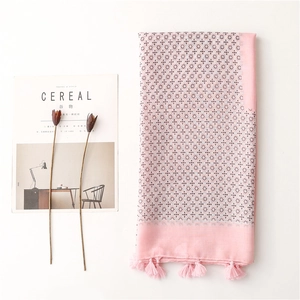 Detail of light pink floral scarf with delicate fringe tassels and elegant texture