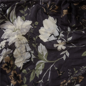 Close-up of floral print fabric with white flowers on a black cotton linen background