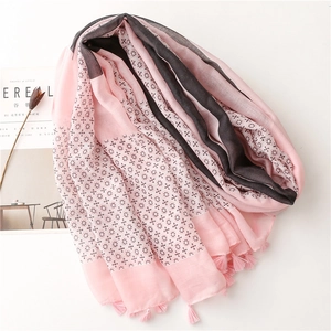 Detail of pink and grey floral scarf with fringe edge next to a Cereal magazine