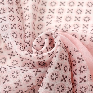 Detail of pink floral fabric showing soft texture and delicate black geometric flower patterns