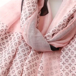 Detail of pink cotton scarf with floral print showing breathable woven fabric texture