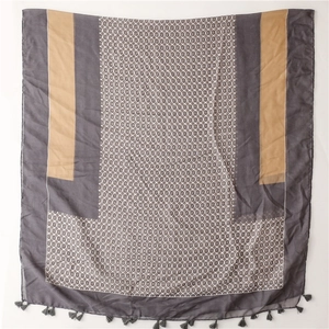 Detail of gray and camel scarf featuring geometric circle patterns and delicate tassels