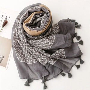 Detail of grey and yellow polka dot scarf with tassels and floral texture