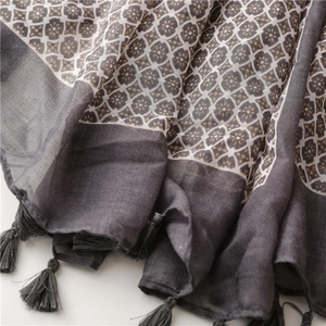 Detail of grey and beige polka dot scarf featuring delicate fringe and cotton texture