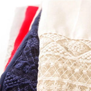 Close-up of delicate floral lace embroidery on soft cotton summer scarf textures