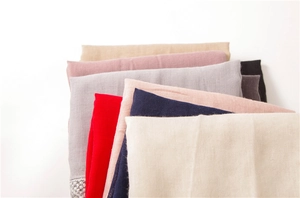 Detailed close-up of cotton linen scarves showing fine texture and embroidery edges