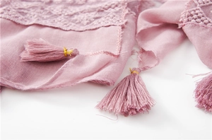 Close-up of lavender silk scarf featuring intricate lace patterns and fringe with gold coils