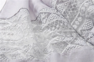 Close-up of lilac scarf with delicate white floral embroidery and lace stitching