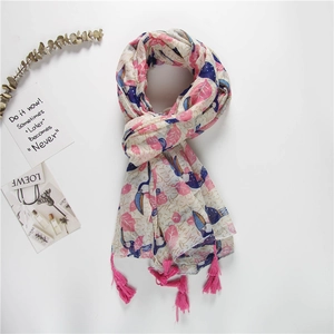 Chic scarf with blue toucan and pink leaf prints featuring bright tassel details