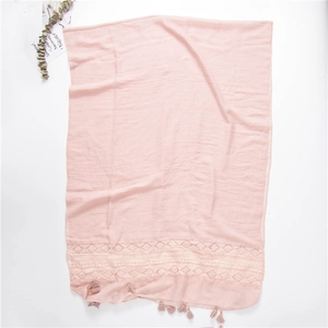 Detail of pink scarf with geometric embroidery lace trim and tassel edge finish