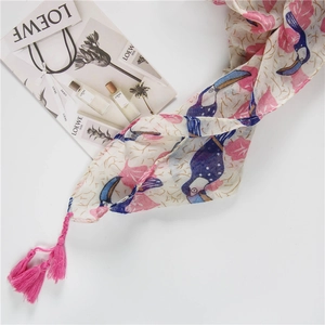 Artistic linen-feel scarf featuring blue toucan and pink leaf prints with tassel details