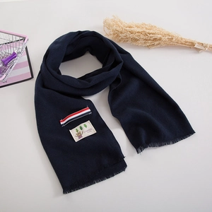 Detail of navy knit scarf with cartoon bear patch and striped ribbon accent for kids
