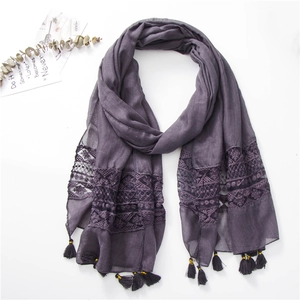 Detailed view of dark grey purple scarf with geometric lace embroidery and soft tassels