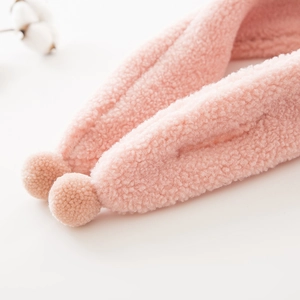 Pink plush baby scarf with soft pom-poms and warm faux lamb wool texture for winter