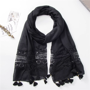 Detail view of black summer shawl featuring floral lace embroidery and elegant fringed edges