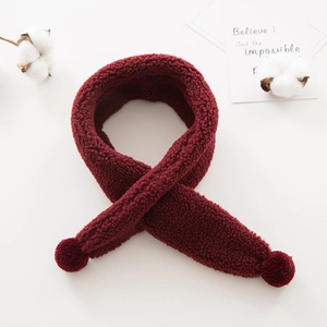 Close-up of wine red plush kids scarf featuring soft fleece texture and round pom-pom detail