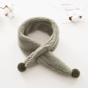 Detailed texture of grey-green plush toddler scarf with soft faux fur and pom-poms