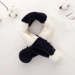 Detail view of plush navy and white contrast scarf with soft fuzzy pompom decorations