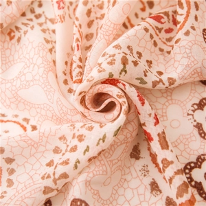 Close-up of lightweight floral scarf fabric showing soft paisley and lace mesh textures
