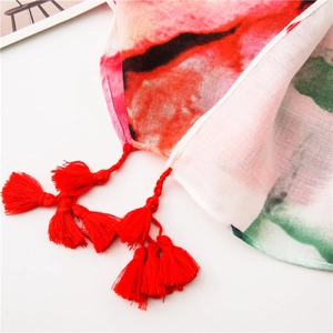 Detailed close-up of abstract red and green print scarf with delicate fringe tassels