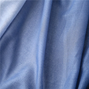 Close-up of blue cotton scarf fabric showing fine twill weave texture and high-quality material